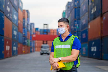 Cheerful factory worker man holding hard hat and looking forward, Happiness engineer at containers cargo conceptの写真素材