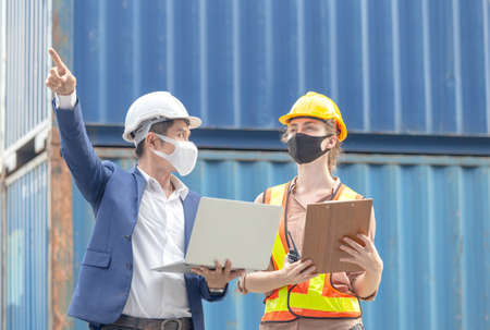 Female engineer and factory worker team checking containers box from cargo, Logistic and teamwork...