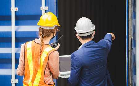 Engineer wearing protection face mask against coronavirus, Foreman worker team checking containers...
