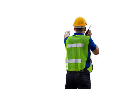 Factory worker in hard hat and safety vest talks on two-way radio, man with clipping path on white backgroundの写真素材