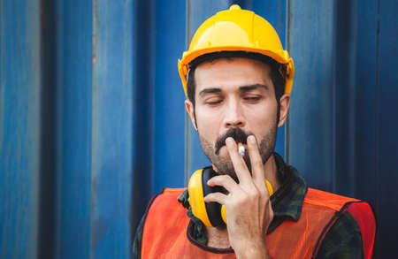 Factory worker with a cigarette smoke break, Labour takes a cigarette breakの写真素材