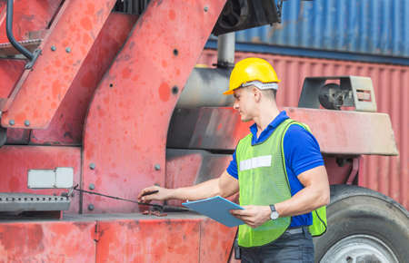 Professional technician pre-check forklift truck at container cargo, safety conceptの写真素材
