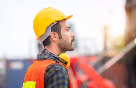 Engineer man in hardhat and safety vest control loading containers box from cargo, Logistic conceptの写真素材