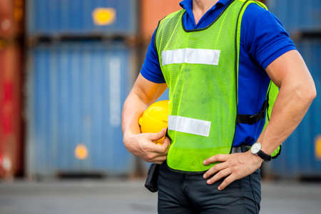 Close up of Engineer, worker man holding hard hat at cargo containersの写真素材