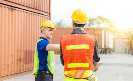 Engineer and foreman worker team checking containers box from cargo with blurred background, Teamwork conceptの写真素材