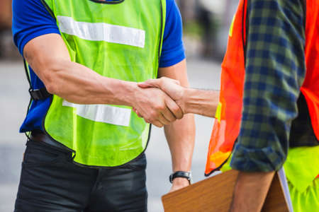 Fatory worker handshake with blurred construction site, Success and Teamwork conceptの写真素材