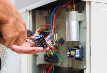 Close up of Air Conditioning Repair, repairman installing magnetic contactor and fixing air conditioning systemの写真素材