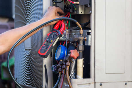 Air Conditioning Repair man hands checking and fixing modern air conditioning system, Technician team checking leakage air conditioning systemの写真素材