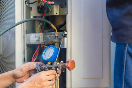 Air Conditioning Repair man hands checking and fixing modern air conditioning system, Technician team checking leakage air conditioning systemの写真素材