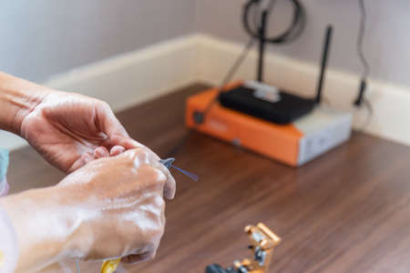 Selective focus of Internet technician man are cutting and installation fiber optic cables, Home IT network conceptの写真素材