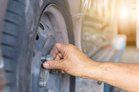 Close up of repair mechanic hands during maintenance work to loosen a wheel nut changing tyre of carの写真素材