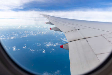 Selective focus Airplane wing view out of the window the cloudy sky background, Travel and Holiday vacation conceptの写真素材