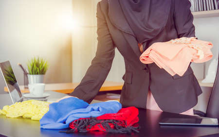 Selective focus of Young businesswoman arab middle eastern muslim looking and checking fabric in officeの写真素材
