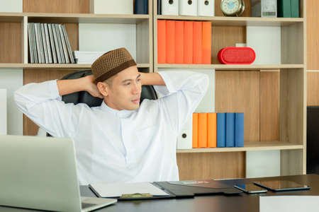 Young business arab middle eastern muslim man relaxing at comfortable office chairの写真素材