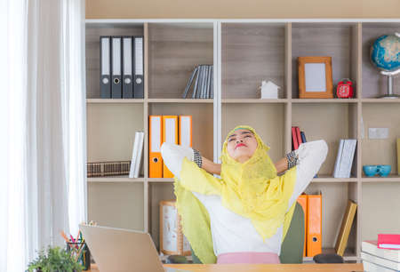 Happiness young business arab middle eastern muslim woman relaxing at comfortable office chair, Work from  home conceptsの写真素材