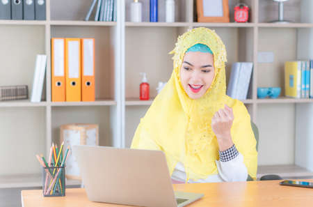 Happy successful lucky young Arab muslim woman smiling joyfully, cheering, feeling excited, gesturing with handの写真素材