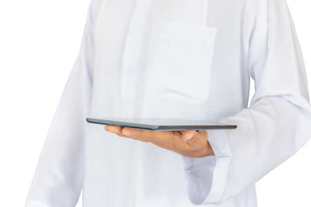 Selective focus of young business muslim man holding tablet in hand with clipping path on white background for Arab technology concept.の写真素材