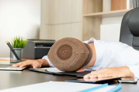 Tired middle eastern businessman wearing headscarf and sleeping in the officeの写真素材