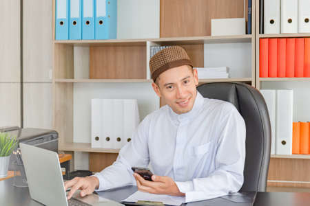 Selective focus of Happy young business arab middle eastern muslim man in officeの写真素材