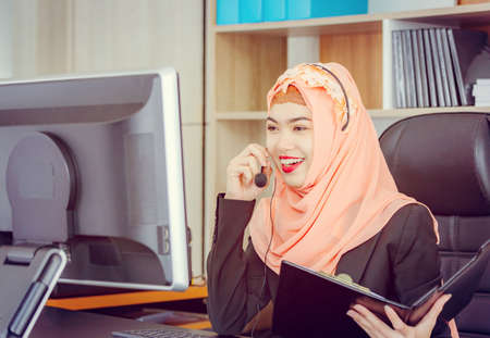 Close up of happiness and smiling young beautiful Arab middle eastern businesswoman with headphones, Professional operator service conceptの写真素材