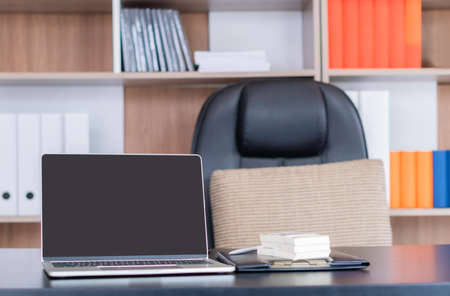 Office desk workplace with laptop and money banknotes on the table in business officeの写真素材
