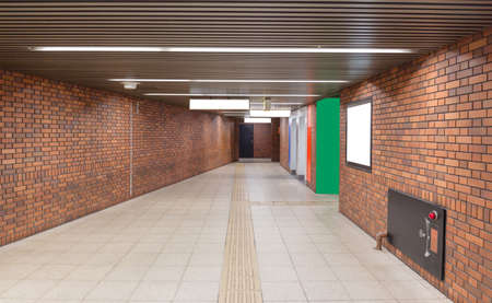Walkway with brown brick wall to subway station