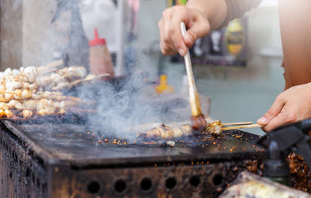 Select focus of woman hand take barbecue octopus grilled Japan street food at inari in Kyoto,Japanの写真素材
