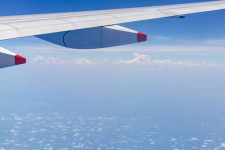Airplane wing view out of the window the cloudy sky background, Travel and Holiday vacation concept