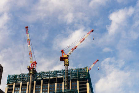 Large crane and building construction site with blue sky backgroundの写真素材