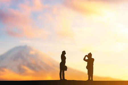 Silhouette of man taking photo of his girlfriend evening blurred sunset background, Happy and enjoy travel conceptの写真素材