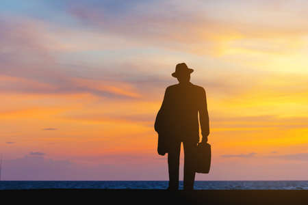 Silhouettes of alone business man with blurred sunset backgroundの写真素材
