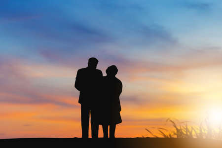 Silhouette of Grandfather grandmother, Senior couple walking evening sunset background, Happy elderly couple conceptの写真素材