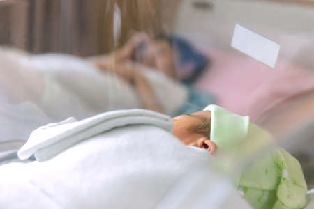 Selective focus of newborn baby boy and mother sleepingの写真素材