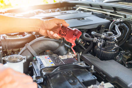 Selective focus, Technician man hand checking car battery on car engine systemの写真素材