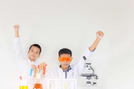 Kids or students scientist celebrates their success with raised arms in chemical tests laboratory, Children science conceptの写真素材