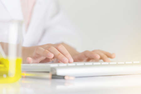 Selective focus of little girl hand typing with keyboard at lab room, science kids concept.の写真素材