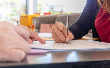 Close up of woman's hand with pen signing document, Deal conceptの写真素材