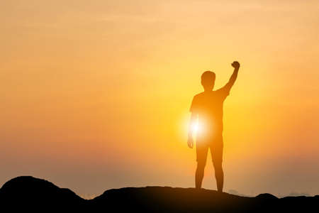 Silhouette of Man with clipping path celebration success happiness on a mountain top on beach evening sky sunset / sunrise background, Sport and active life concept.の写真素材