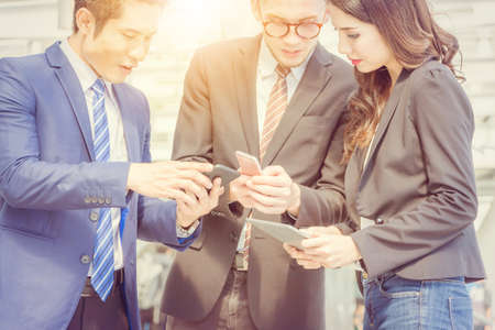 Close up of Happy business team looking good news from smartphone in your hand.の写真素材