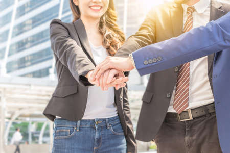 Success Teamwork Concept, Business people team with clipping path joining hands over blurred city...