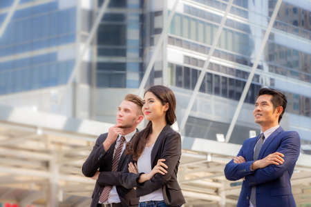 Smart young business man and business women team looking into the sky with blurred backgroundの写真素材