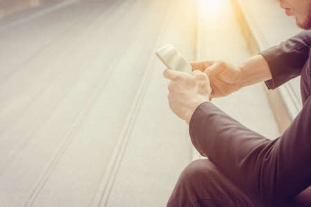 Close up of young business man using mobile smartphone blurry backgroundの写真素材
