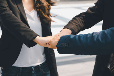 Success Teamwork Concept, Business people team joining hands over blurred city background