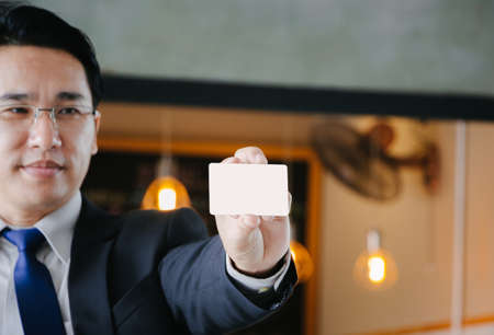 Business man showing his blank business card / credit card , mock up conceptの写真素材