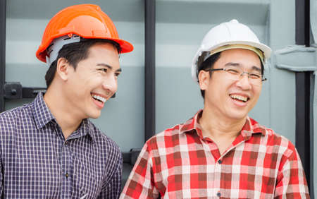 Cheerful engineer man and foreman team at construction site, Happiness factory worker in hard hat at...