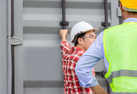 Engineer and foreman worker team checking containers box from cargoの写真素材