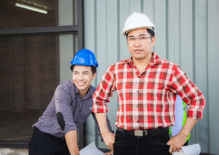 Team of Engineer planning group project partners meeting at building site, Man in hard hat standing and looking at camera at construction siteの写真素材