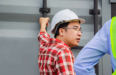 Engineer and foreman worker team checking containers box from cargoの写真素材
