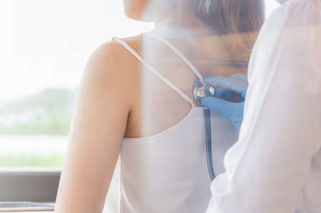 Young woman at clinic and doctor health check using stethoscope, Heathcare and medicineconceptの写真素材