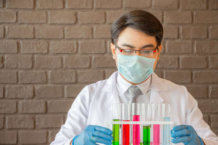 Doctor analyzing medical test tubes examining beaker with fluid, Scientist researching and learning in a laboratoryの写真素材